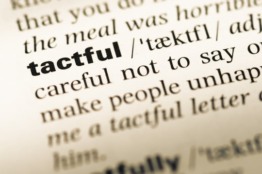 Close up of old English dictionary page with word tactful