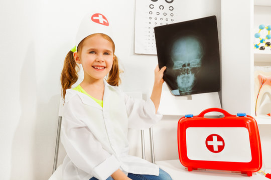 Girl In Doctor Costume Playing Dentist With X-ray