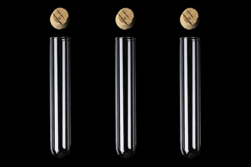 Three glass transparent test tubes with cork above on black background