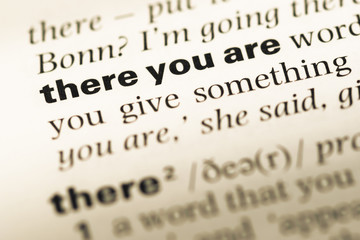 Fototapeta premium Close up of old English dictionary page with word there you are