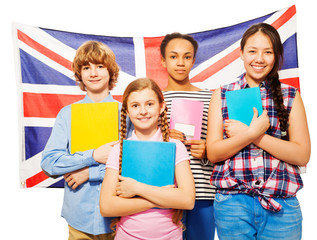 Four happy students standing against British flag