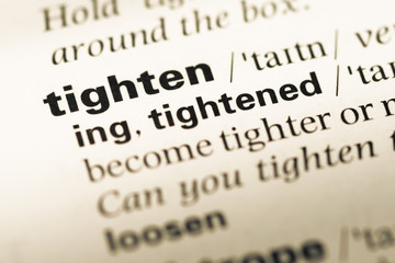 Obraz premium Close up of old English dictionary page with word tighten