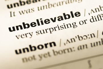 Close up of old English dictionary page with word unbelievable