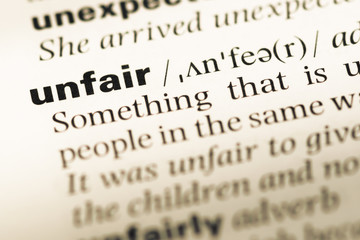 Close up of old English dictionary page with word unfair