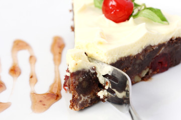 eating bite of served slice of delicious chocolate brownie cake with cherry