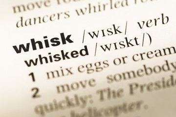 Fototapeta premium Close up of old English dictionary page with word whisk