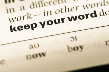 Close up of old English dictionary page with word keep your word