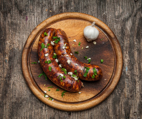 Homemade sausages on wooden cutting board top view