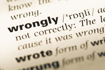 Obraz premium Close up of old English dictionary page with word wrongly