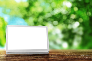 Modern tablet against blurred green background