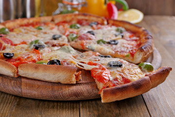 Pizza with cheese on board and wooden table background
