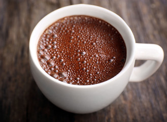 Cup of hot coffee on rustic wooden background