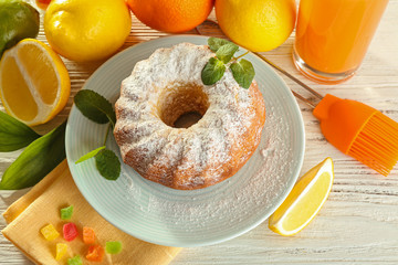 Delicious citrus cake with fruits on wooden table
