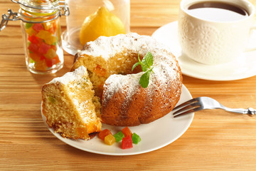 Sliced delicious citrus cake  with cup of coffee on wooden table