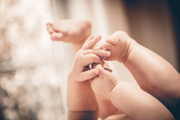 Baby holds his small hands their feet close-up