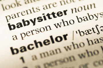 Obraz premium Close up of old English dictionary page with word babysitter