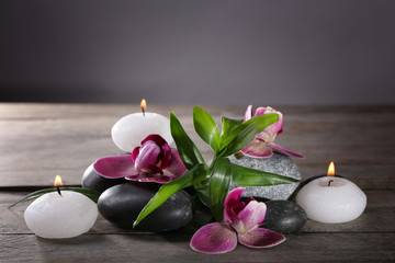 Spa still life with beautiful flower and candlelight on grey background