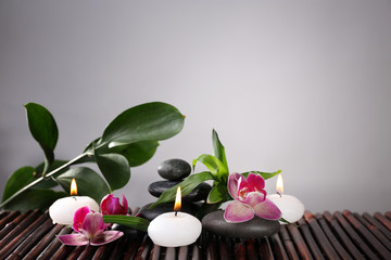 Spa still life with beautiful flower and candlelight on grey background