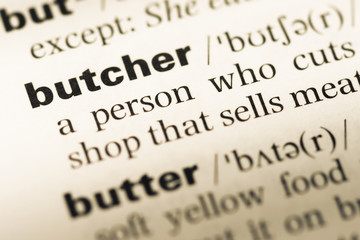 Obraz premium Close up of old English dictionary page with word butcher