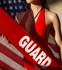 American woman lifeguard with rescue tube and whistle equipment against USA flag