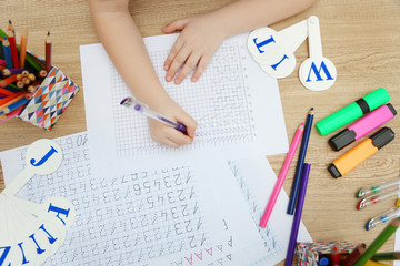 Little girl learning to draw at the table