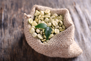Green coffee beans in a bag  on wooden table