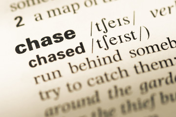 Fototapeta premium Close up of old English dictionary page with word chase