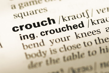 Close up of old English dictionary page with word crouch