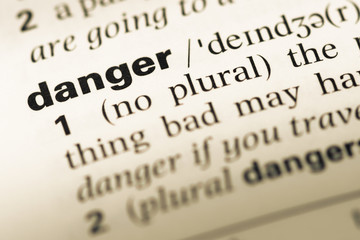 Obraz premium Close up of old English dictionary page with word danger