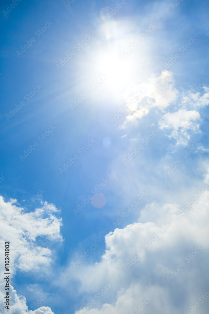 Wall mural view of blue sky with sun and sunrays between the clouds