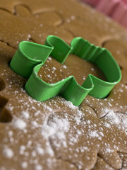 close-up shot of green plastic gingerbread cutter on dough.