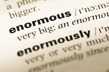 Fototapeta premium Close up of old English dictionary page with word enormous