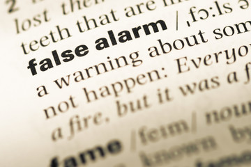 Close up of old English dictionary page with word false alarm
