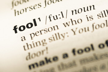 Close up of old English dictionary page with word fool