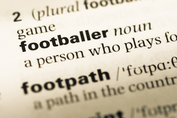 Close up of old English dictionary page with word footballer