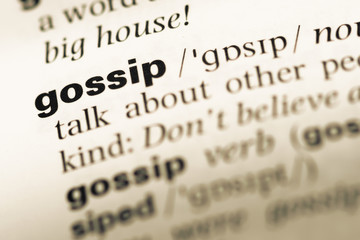 Close up of old English dictionary page with word gossip
