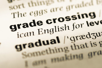 Obraz premium Close up of old English dictionary page with word grade crossing