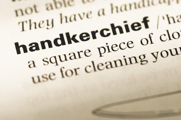 Obraz premium Close up of old English dictionary page with word handkerchief