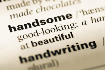 Close up of old English dictionary page with word handsome