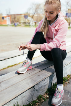 Young woman in the city getting ready for a run. © lumenphotos