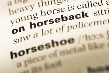Close up of old English dictionary page with word on horseback