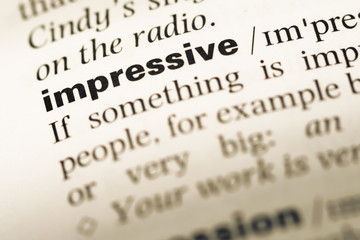 Close up of old English dictionary page with word impressive