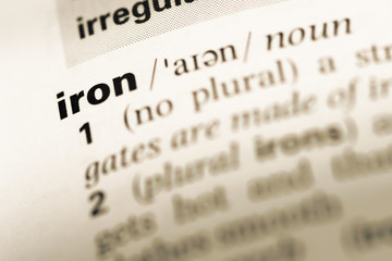 Close up of old English dictionary page with word iron