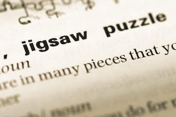 Close up of old English dictionary page with word jigsaw puzzle