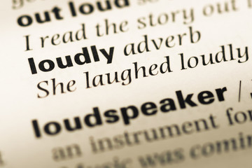 Obraz premium Close up of old English dictionary page with word loudly