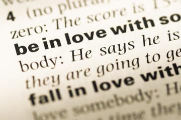 Close up of old English dictionary page with word in love with