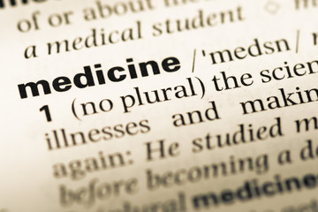 Fototapeta premium Close up of old English dictionary page with word medicine