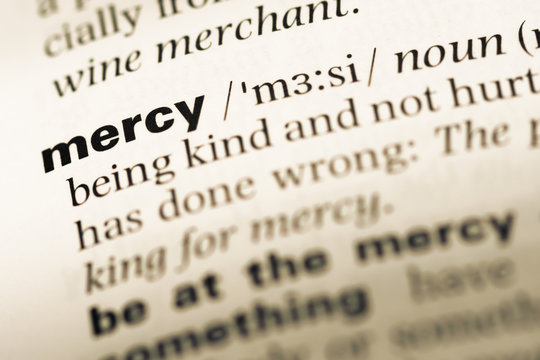 Close up of old English dictionary page with word mercy