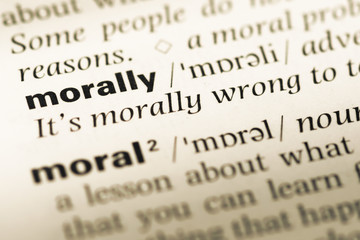 Fototapeta premium Close up of old English dictionary page with word morally