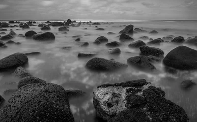 Photo sur Plexiglas Noir et blanc Longue exposition en noir et blanc des vagues s& 39 écoulant sur les roches volcaniques à Hawaï.